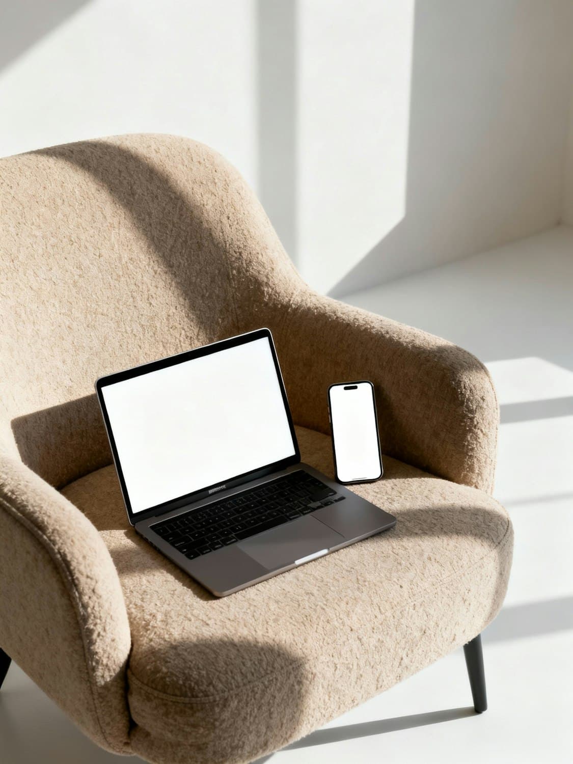 A laptop open on a tan leather sofa in warm afternoon light